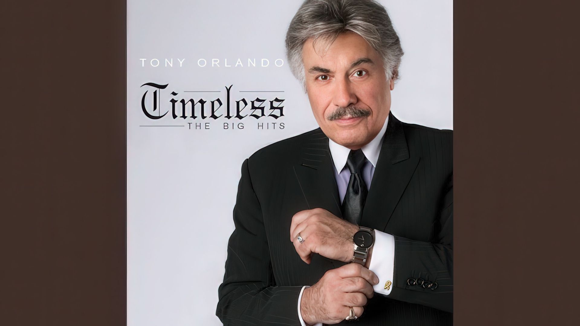 Album cover of 'Timeless: The Big Hits' featuring Tony Orlando, dressed in a black suit, looking at the camera while adjusting his watch.