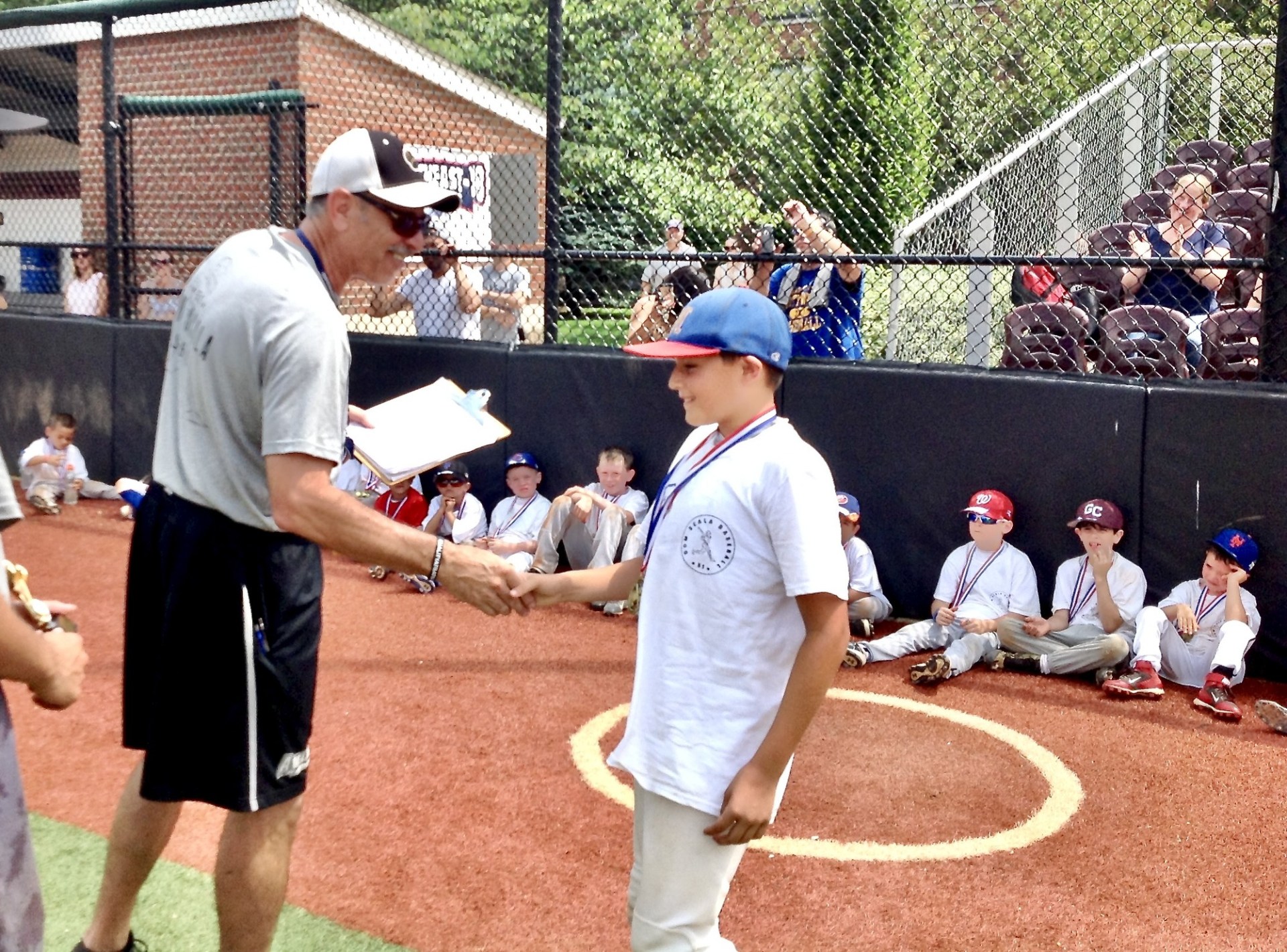 Dom Scala handing a medal to a young camper